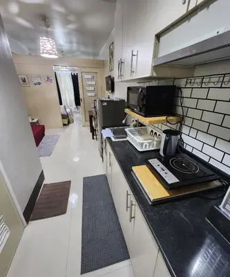 a kitchen with a counter top and a stove top oven at MNM Place - Sea Residence 0A in Manila