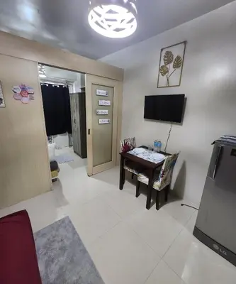 a living room with a table and a television at MNM Place - Sea Residence 0A in Manila
