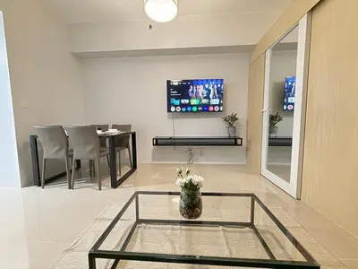 a living room with a table and a tv on the wall at Jazz mall Tower 4 Rm 323 Spacious 1 bedroom with Balcony netflix 100mbps in Manila