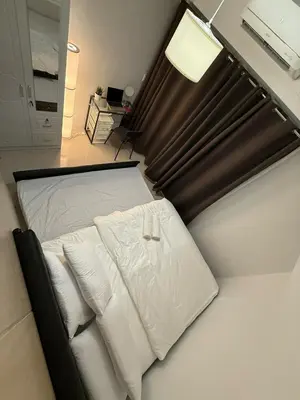 a bedroom with a bed with white pillows at Jazz mall Tower 4 Rm 323 Spacious 1 bedroom with Balcony netflix 100mbps in Manila
