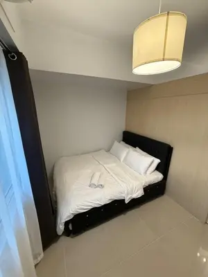 a bedroom with a bed with white sheets and pillows at Jazz mall Tower 4 Rm 323 Spacious 1 bedroom with Balcony netflix 100mbps in Manila