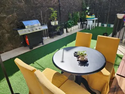 a patio with a table and chairs and a grill at Family room with private pool in Manila