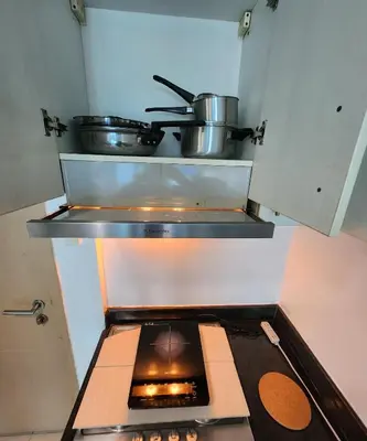 an oven with pots and pans on top of it at MNM Place - Sea Residence 0F in Manila