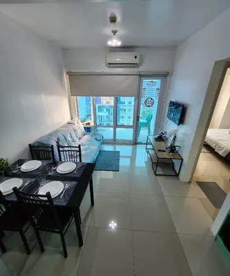 a living room with a table and a couch at MNM Place - Sea Residence 0F in Manila