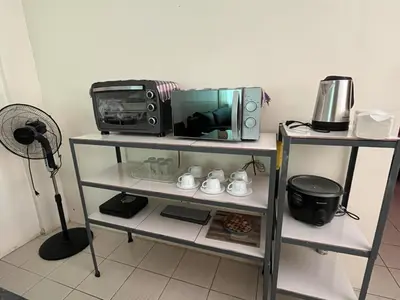 a television and a microwave on a shelf at NRD Staycation Transient House in Dasmariñas