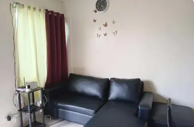 a living room with a black couch and birds on the wall at NRD Staycation Transient House in Dasmariñas