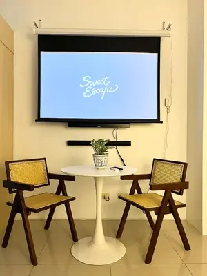 a white table with two chairs and a projection screen at Jazz Residence T2 Rm 405 Homey Muji Inspired Staycation Big Screen Cinema in Manila