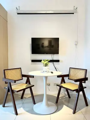 a table and chairs in a room with a tv at Jazz Residence T2 Rm 405 Homey Muji Inspired Staycation Big Screen Cinema in Manila