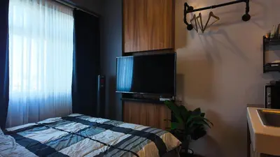 a bedroom with a bed and a flat screen tv at Studio near SM Megamall 400MBPS Netflix Disney HBO in Manila