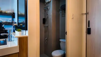 a bathroom with a shower with a toilet and a sink at Studio near SM Megamall 400MBPS Netflix Disney HBO in Manila