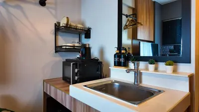 a kitchen with a sink and a microwave at Studio near SM Megamall 400MBPS Netflix Disney HBO in Manila