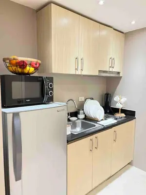 a kitchen with a white refrigerator and a microwave at Makati Room 381 1 br deluxe SMJazz T2 residence New in Manila