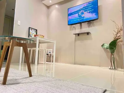 a room with a glass table and a tv on a wall at Makati Room 381 1 br deluxe SMJazz T2 residence New in Manila