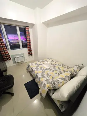 a bedroom with a bed in a room with a window at MNM Place - Sea Residence 8D in Manila