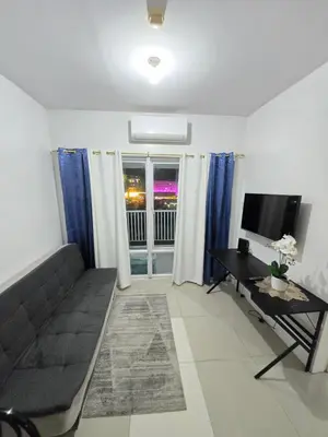 a living room with a couch and a television at MNM Place - Sea Residence 8D in Manila
