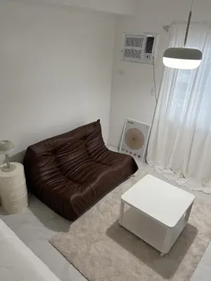 a living room with a brown couch and a table at The Bauhaus near Eastwood in Manila