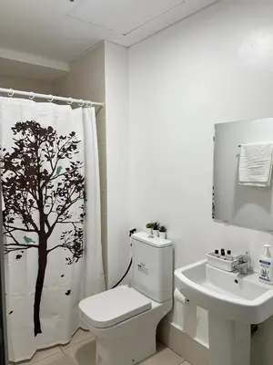 a bathroom with a toilet and a tree shower curtain at The Bauhaus near Eastwood in Manila