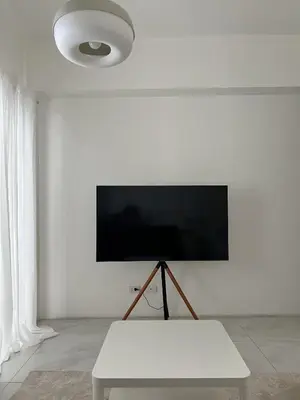 a white room with a tv on a white wall at The Bauhaus near Eastwood in Manila