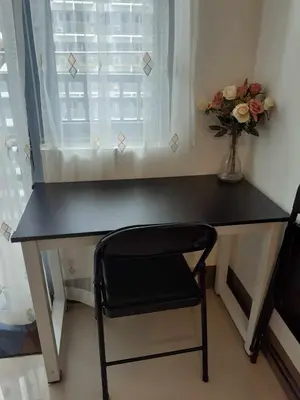 a black desk with a chair and a vase of flowers at Condo Staycation Fame Residences T2 Mandaluyong Philippines in Manila