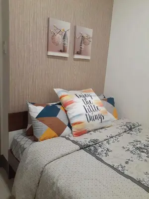 a bedroom with a bed with a bunch of pillows at Condo Staycation Fame Residences T2 Mandaluyong Philippines in Manila
