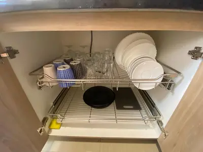 a cabinet with plates and dishes on a shelf at The Grand Staycation at MOA - Unit 7102 Hotel-like in Manila