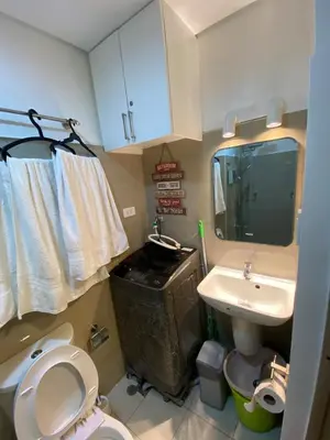 a bathroom with a toilet and a sink at The Grand Staycation at MOA - Unit 7102 Hotel-like in Manila
