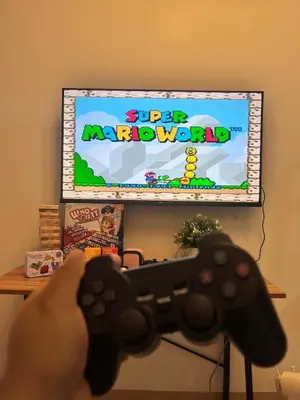 a person holding a video game controller in front of a tv at Cozy Haven 2 in Manila