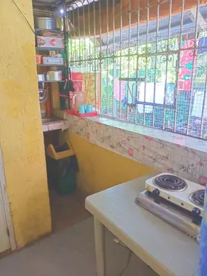 a kitchen with a stove and a table and a window at Springbreak Residence in Manila