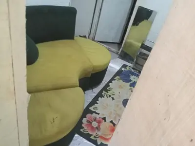 a living room with a yellow chair and a rug at Springbreak Residence in Manila