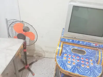 a desk with a computer and a fan in a room at Springbreak Residence in Manila