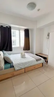 a bedroom with a large bed with a window at MNM Place - Sea Residence 1B in Manila