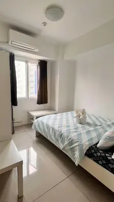 a bedroom with a bed with a blue and white blanket at MNM Place - Sea Residence 1B in Manila