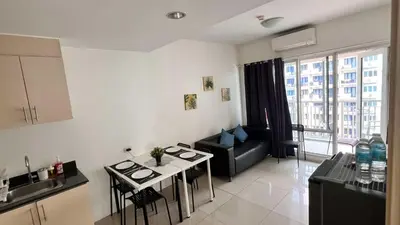 a kitchen and a living room with a couch and a table at MNM Place - Sea Residence 1B in Manila