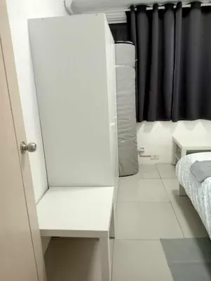 a white cabinet in a room with a bed at MNM Place - Sea Residence 1B in Manila