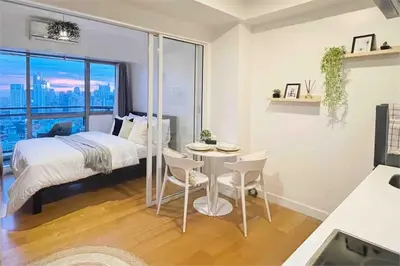 a bedroom with a bed and a table and chairs at The Serene Escape Ph Rockwell Balcony View 1BR in Manila