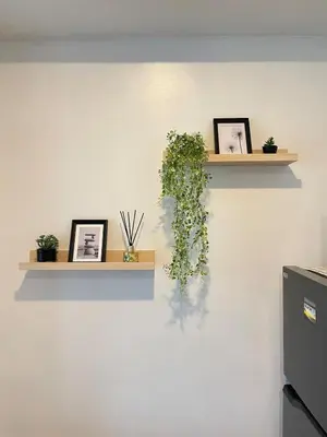 a wall with two shelves with plants on it at The Serene Escape Ph Rockwell Balcony View 1BR in Manila