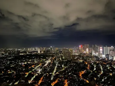 a view of a city at night at The Serene Escape Ph Rockwell Balcony View 1BR in Manila