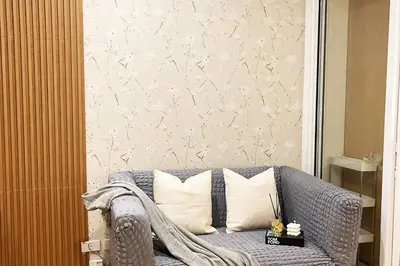 a living room with a couch with pillows at The Serene Escape Ph Rockwell Balcony View 1BR in Manila