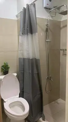 a bathroom with a toilet and a shower at Shore Residence a32 shortwalk Mall of Asia in Manila