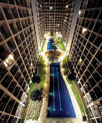 an overhead view of a pool between two tall buildings at Shore Residence a32 shortwalk Mall of Asia in Manila