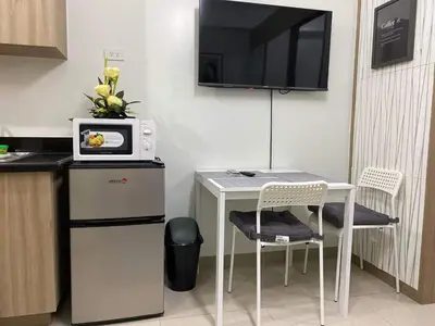 a small kitchen with a white table and a microwave at Shore Residence a32 shortwalk Mall of Asia in Manila