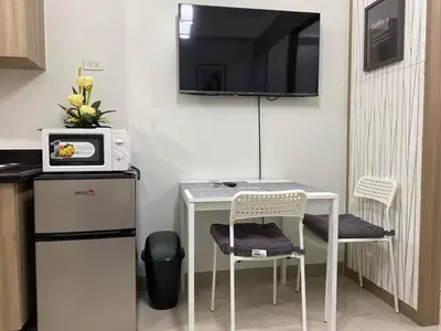 a small kitchen with a table with two chairs and a microwave at Shore Residence a32 shortwalk Mall of Asia in Manila
