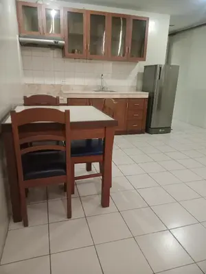 a kitchen with a table and a refrigerator at Joyce Apartelle San Juan in Manila