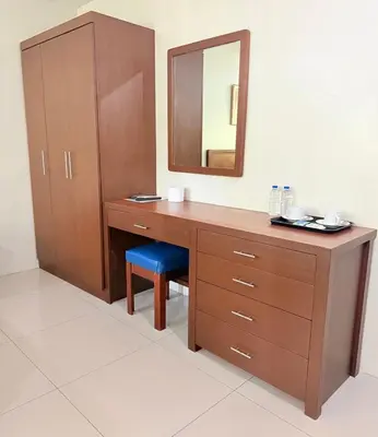 a bathroom with a wooden desk with a mirror and a stool at Joyce Apartelle San Juan in Manila