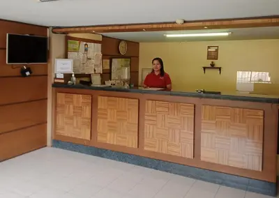 a woman standing at the counter of a restaurant at Joyce Apartelle San Juan in Manila