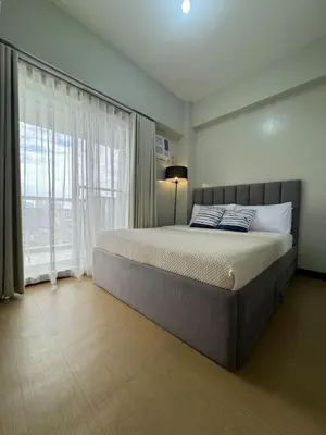 a bedroom with a large bed and a large window at 2BR Resort Type condo w city view Sheridan in Manila
