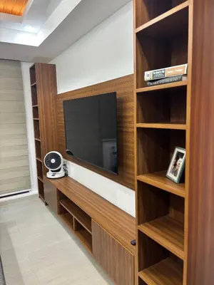 a living room with a tv and wooden shelves at The Villa at Azure South - Bahamas in Manila