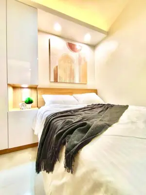 a bedroom with a bed with a black blanket on it at Scandi-Style & Organic condo Shore 3 MOA in Manila
