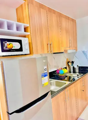 a kitchen with a microwave on top of a refrigerator at Scandi-Style & Organic condo Shore 3 MOA in Manila
