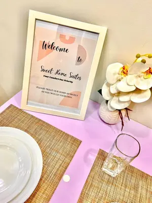 a table with a sign and a plate and flowers at Scandi-Style & Organic condo Shore 3 MOA in Manila